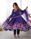 Woman wearing a purple floral dress with a matching dupatta in a bright room.