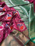 Close-up of a pink and green saree with floral patterns