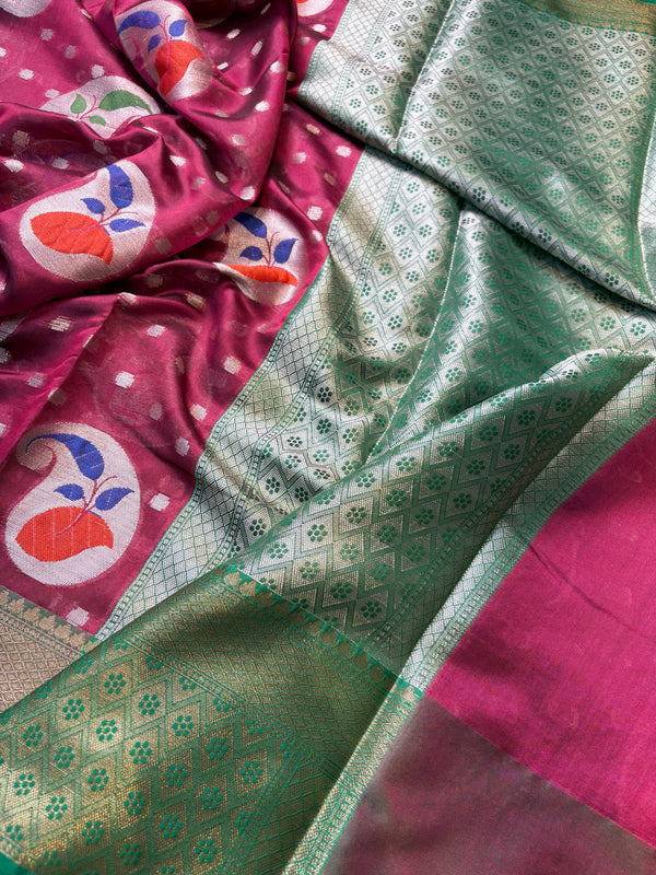Close-up of a pink fabric with floral patterns and green patterned fabric.