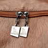Close-up of a brown leather bag with metal zipper and 'WSDS' charms.