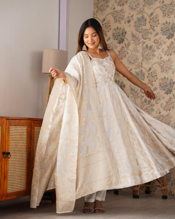 Woman in a white traditional outfit standing in a room with floral wallpaper.