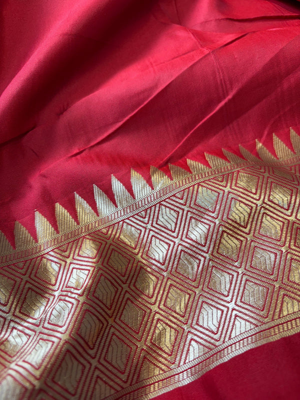 Close-up of a red fabric with gold geometric pattern