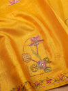 Close-up of a yellow fabric with intricate floral embroidery