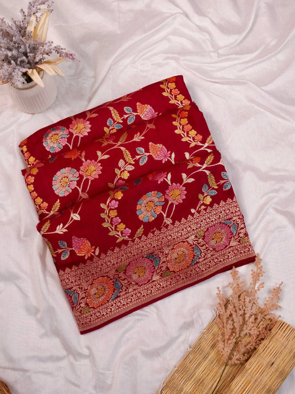 Red embroidered fabric on a white surface with decorative elements.