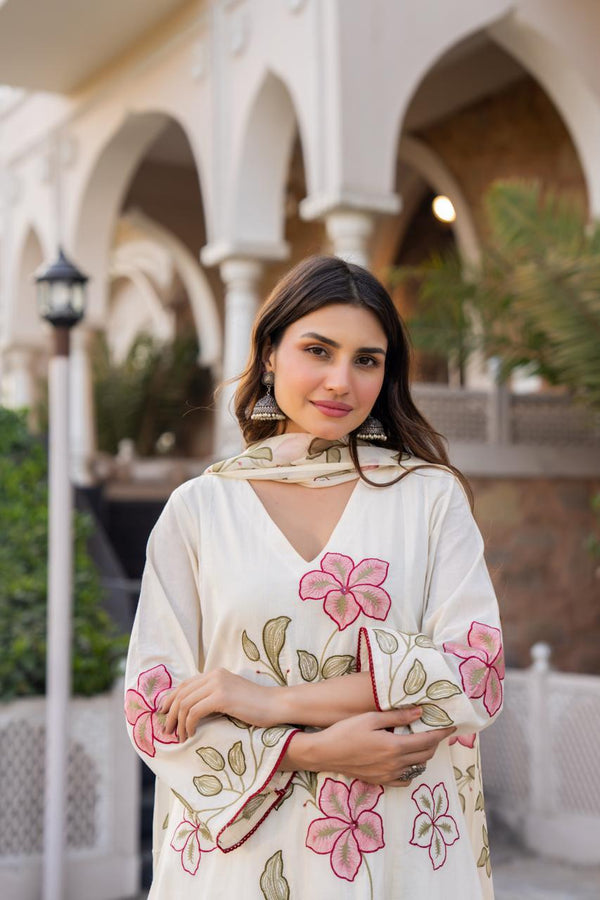 Woman wearing a floral dress standing in front of an architectural building.