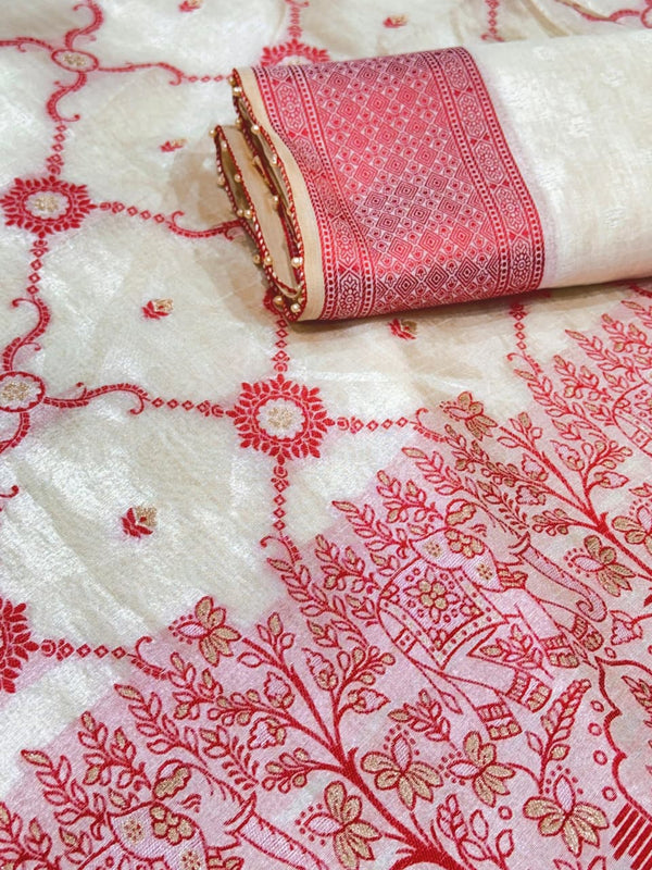 White fabric with red and gold intricate patterns, rolled up