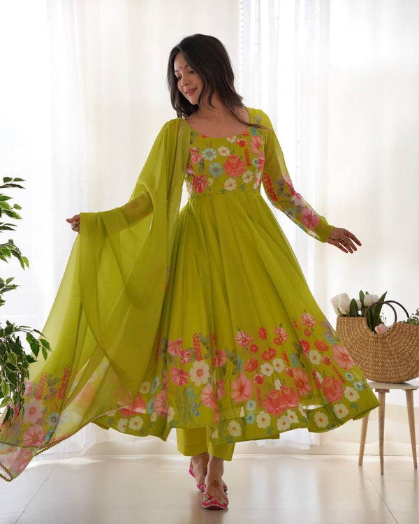 Woman wearing a bright green floral dress in a bright room.