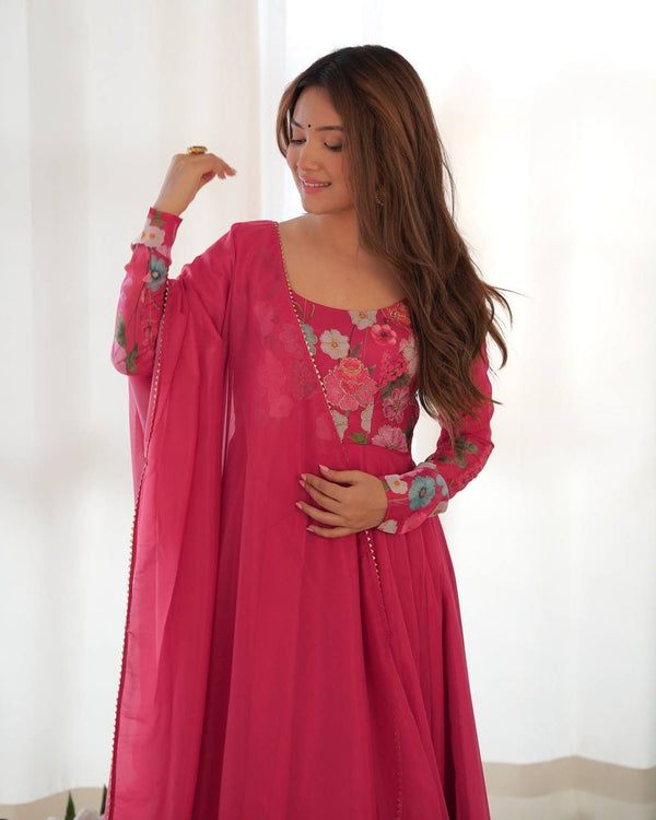 Woman wearing a pink embroidered traditional outfit against a white background