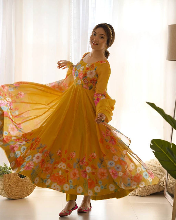 Woman in a yellow floral dress posing in a bright room.