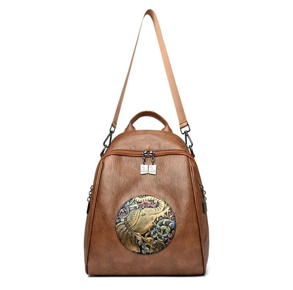 Brown leather backpack with decorative emblem on a white background