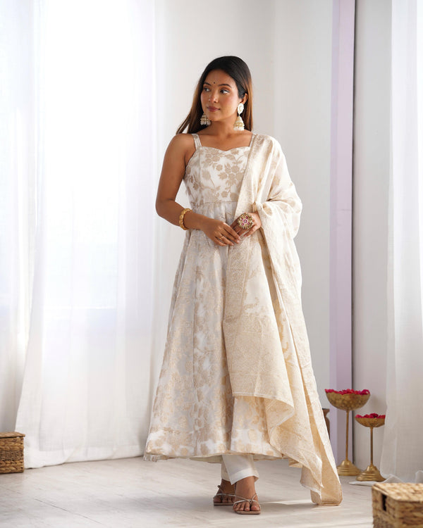Woman wearing a white floral dress with a matching dupatta in a minimalistic setting.
