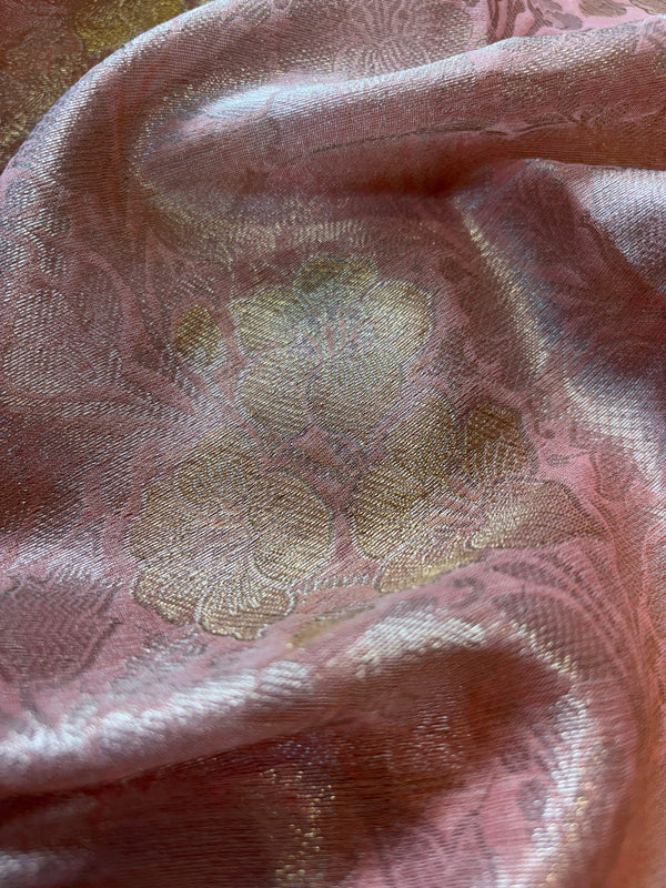 Close-up of pink fabric with gold floral patterns