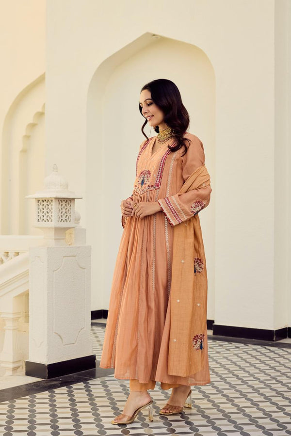 Woman in a peach traditional outfit standing in a decorative interior gysy studios setting