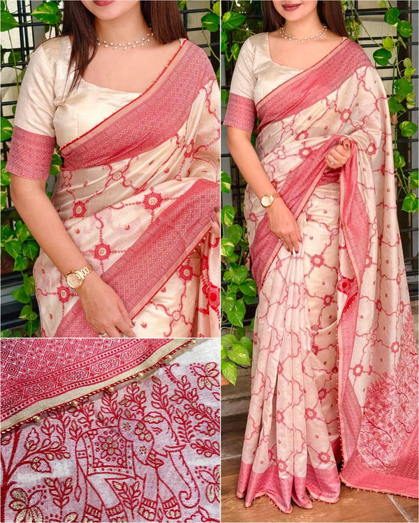 White saree with pink border and intricate patterns, worn by a model against a green leafy background.