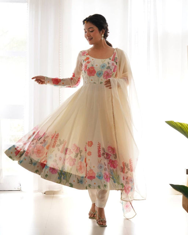 Woman wearing a floral dress with a sheer dupatta in a bright room.