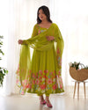 Woman wearing a green floral dress with a matching dupatta in a bright room.