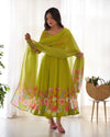 Woman wearing a bright green floral dress with a matching dupatta in a bright room.