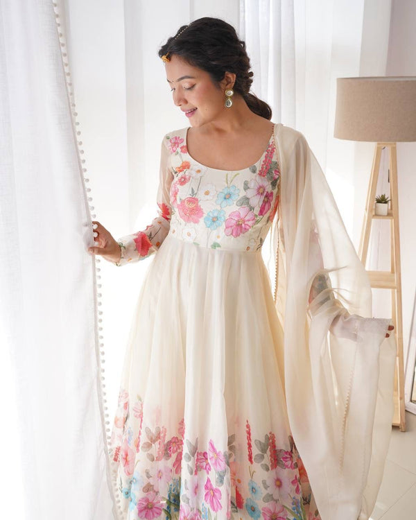 Woman wearing a floral dress with a sheer dupatta in a bright room.